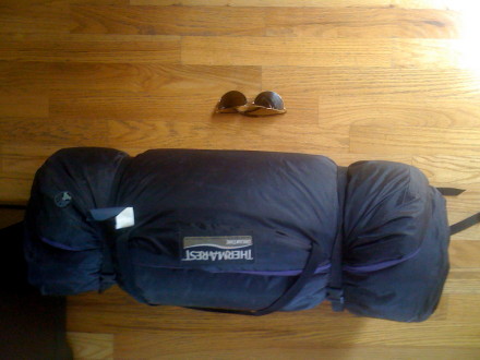 I think that you would have a hard time getting it to fit in your carry on bag.  The Luxury Map might be a better choice.  Here is a pic of my dreamtime crushed down about as far as it could go.  The sunglasses are for scale.
