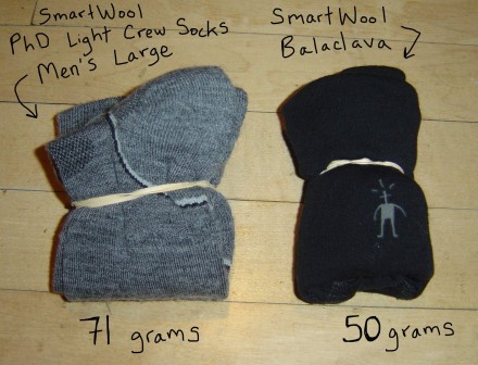 It weighs 50 grams, or 1.75 ounces.  It packs down to a bundle smaller than a pair of the SmartWool PhD Lightweight crew socks, which in comparison weigh 71 grams, or 2.50 ounces, for a men's size large.