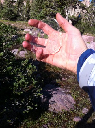 Spent two nights with heavy rain or hail and winds in the high Uintas by Amethyst Lake (10,740 ft.)  The tent did great at keeping water from going through the fly.  Water did absorb through the two pole points that hold the carbon pole on the fly but not to the point of their being any leakage into the tent.  The top of the tent is actually quite flat and pooled water through the night and in the morning their was a nice ice piece sitting on top of the tent but didn't have any leakage or water enter the tent.  The fly was pulled snug to keep it over the edges of the tent and the ends of the tent were pulled out with line and stakes to ensure no leakage at head or foot.  I feel the tent did well with the quantity of wind, hail, and rain we experienced.  You may want to make sure you take some extra line and stakes for the head and foot of the tent.  I just used one of the tie down lines for heavy winds and a rock to keep them pulled out.  Fly seems to be very waterproof material that doesn't let water absorb through and sheds well and dries fast.