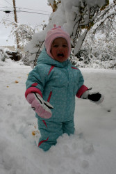 She hates the snow but at least she has a cute snowsuit