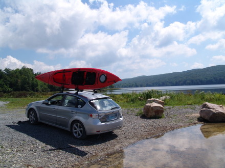I use it as a single more often than as a tandem. Sure, it ways a hefty 73 lbs, but, after lifting it on top of our Subaru Impreza OBS (2/10ths of an inch taller than the stock height, not much but it gives you a base height) several times, it does get much easier. Think, lifting weights. We have a Yakima Bow Down Kayak rack which sits pretty high on top of factory bars. Probably another 6" up but it is nothing a mostly healthy person can't handle. No offense to the ladies, but if you are not into lifting weights, strength training, or are all around fit, it may be a tad more difficult for you. But, with some ingenuity, and a fulcrum point above the car, you as well can get it onto your roof rack.